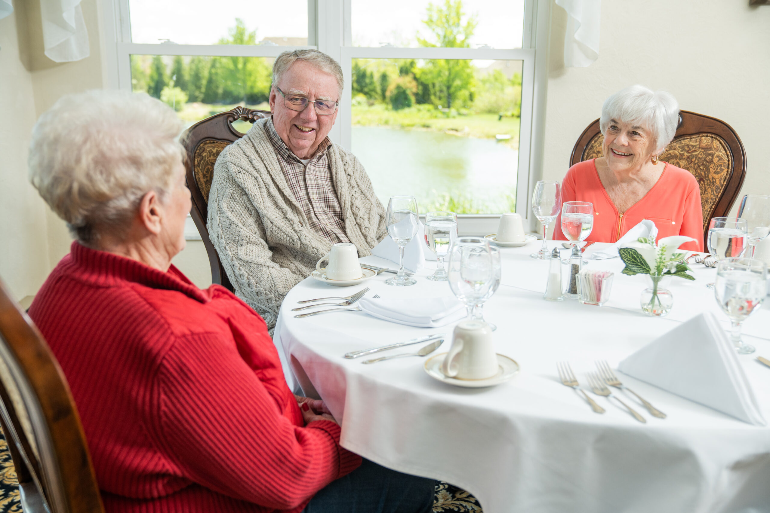Seniors dining together in a bright, welcoming setting, showcasing the supportive community atmosphere at Mari de Villa Senior Living.