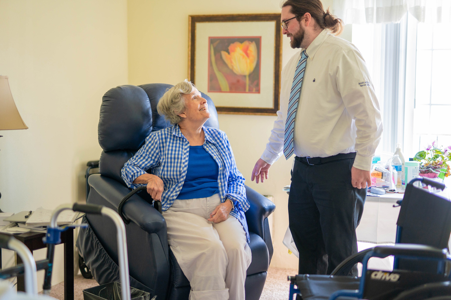 A senior resident looking comfortable and smiling up at a staff member at Mari de Villa Senior Living.