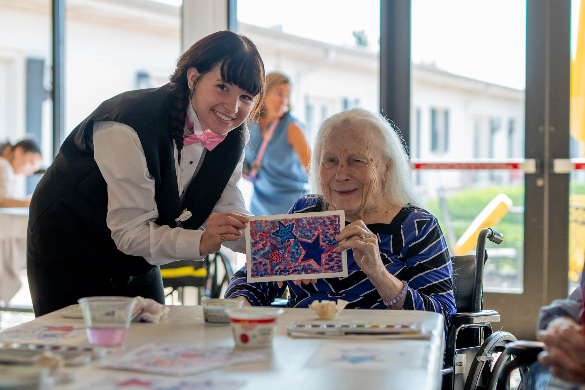 Caregiver helping a senior resident with an art therapy session at Mari de Villa.