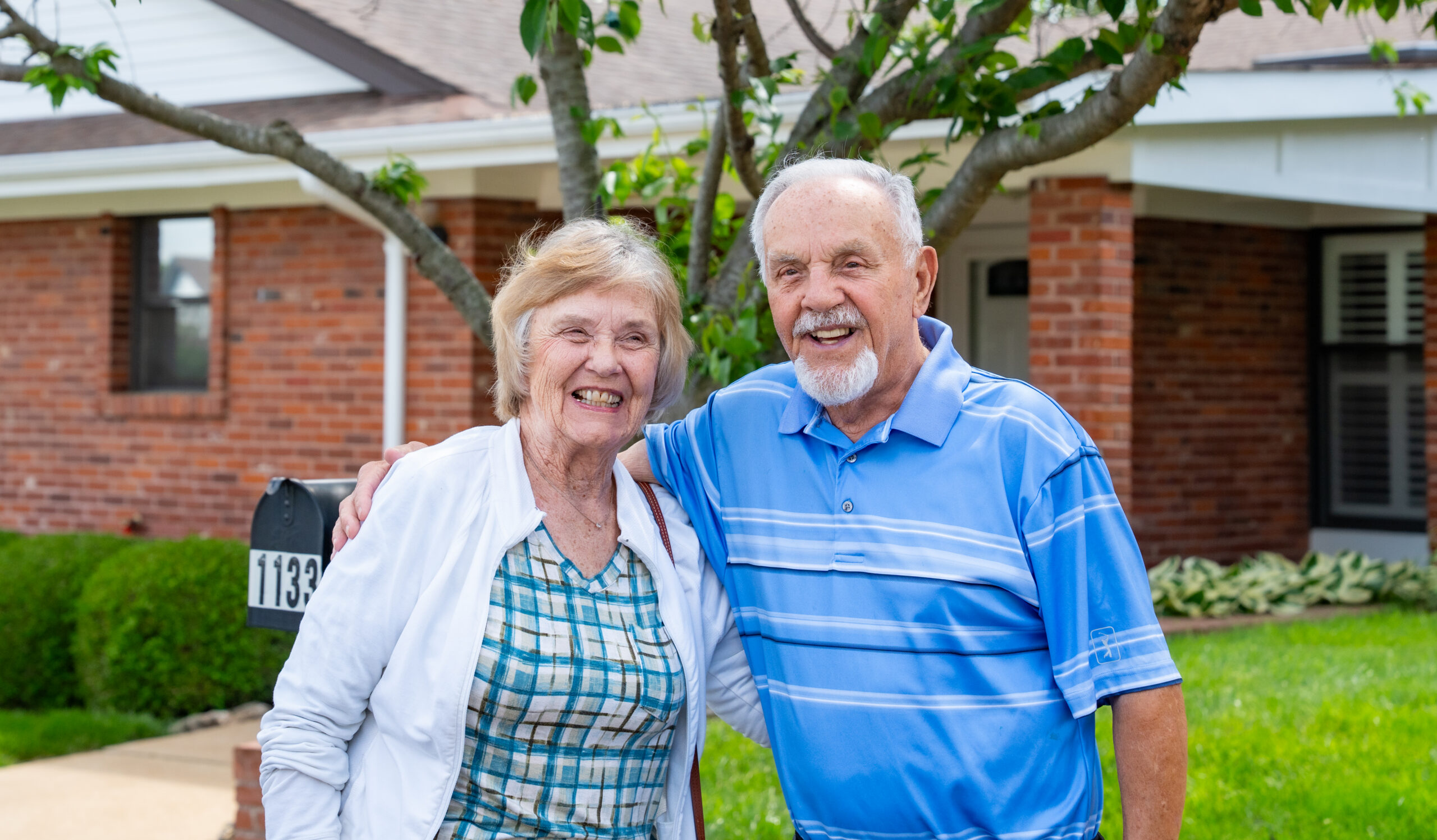 A happy senior couple laughing together outside their private residence at Mari de Villa, showcasing the neighborhood feel and individual house-style living of the Villa Estates in St. Louis.